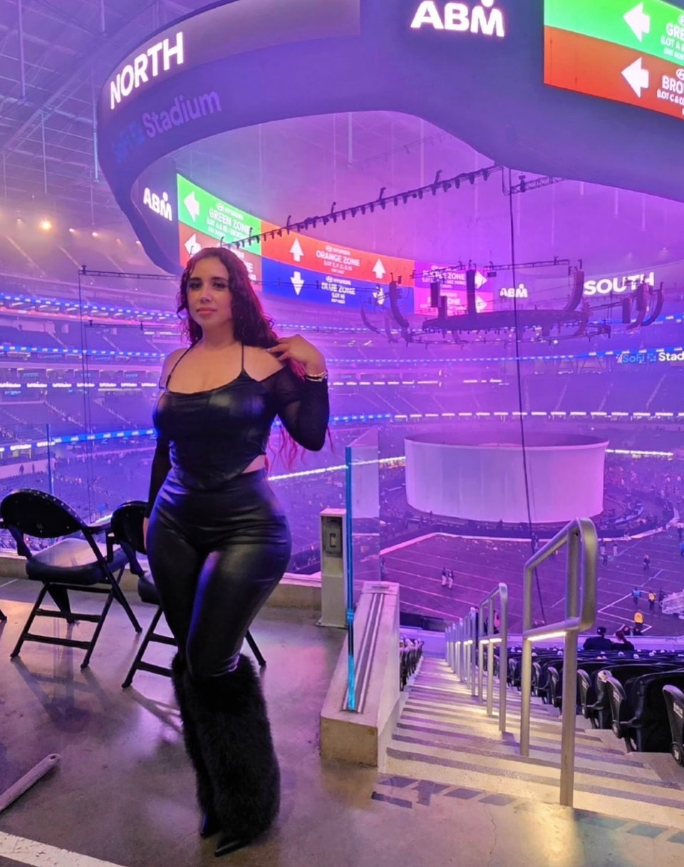 Wendy Estrada dressed in black inside a purple-lit stadium